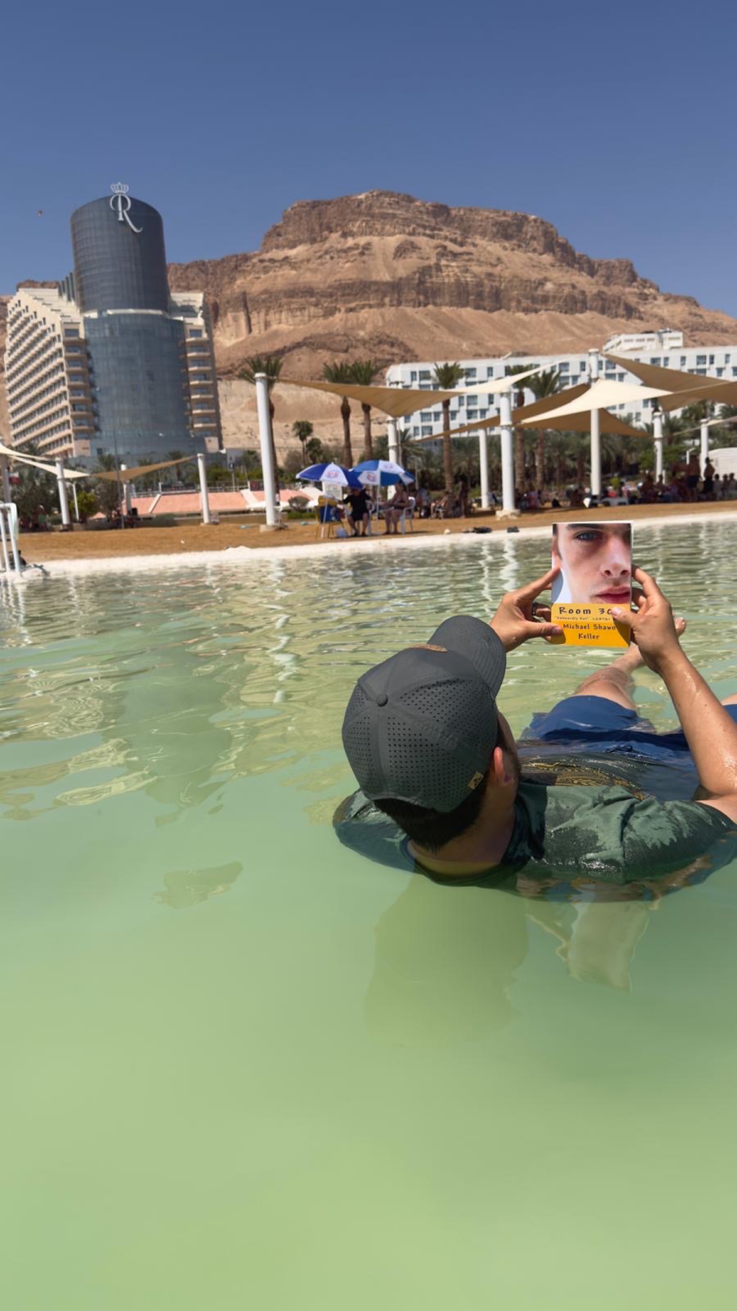 Un lector flotando en el Mar Muerto con Room 308